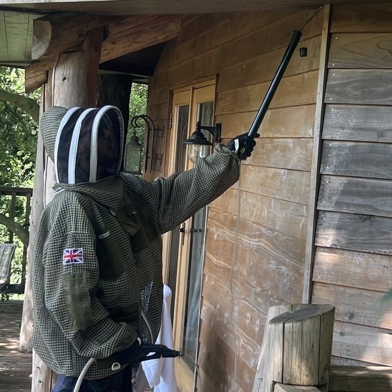 Pest controller in a bee suit carrying out pest control